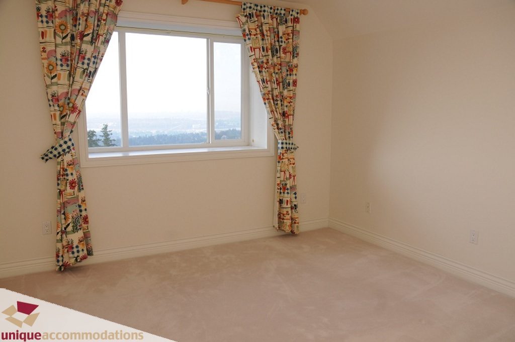 Bright bedroom with floral curtains and a city view. - 4139 Citadel Court, North Vancouver