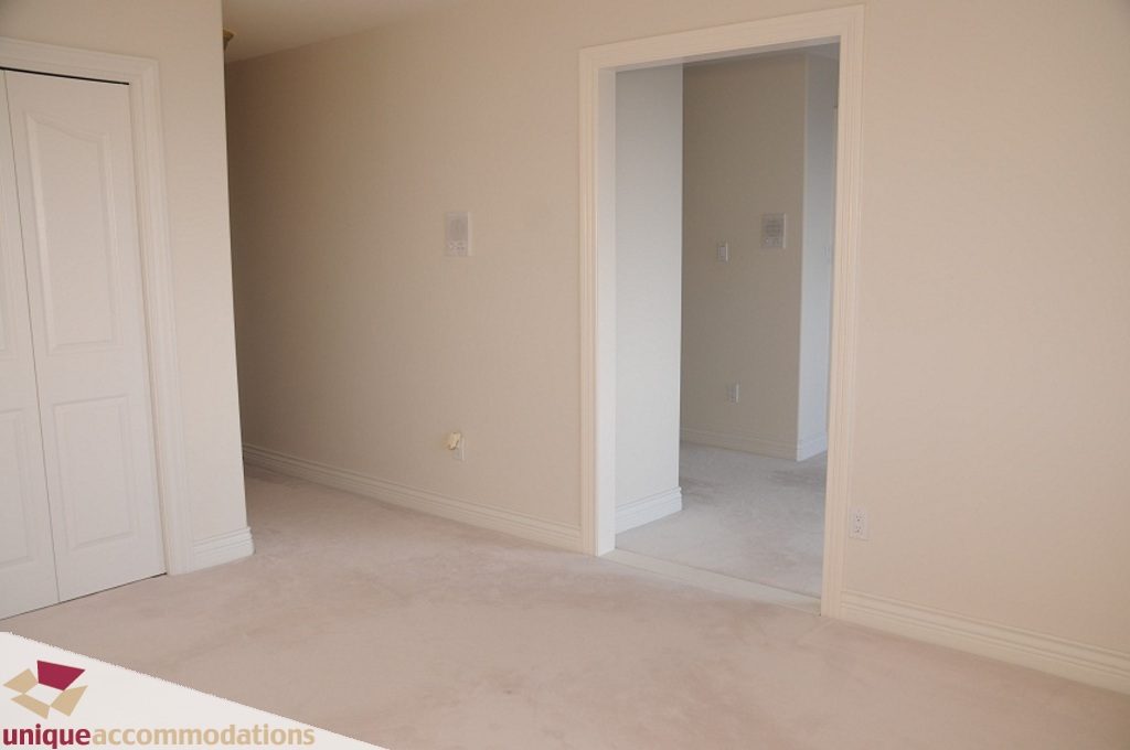 Spacious living room with neutral carpet and white trim. - 4139 Citadel Court, North Vancouver