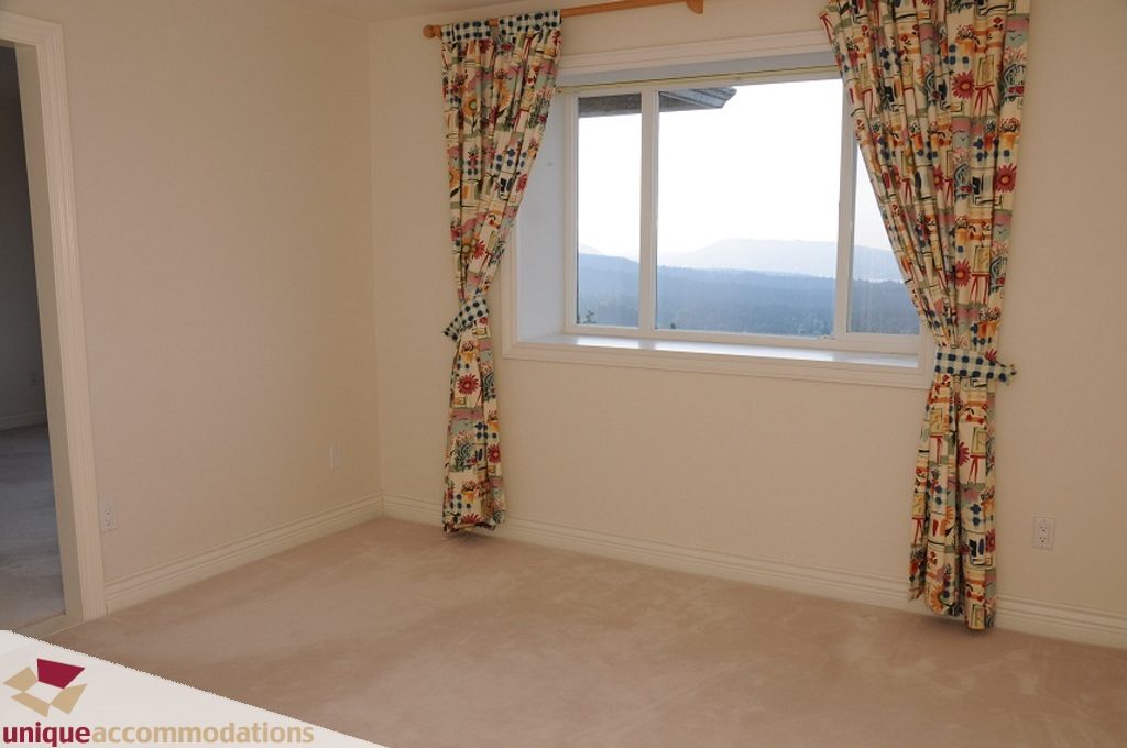 Bright living room with large window and scenic mountain view. - 4139 Citadel Court, North Vancouver