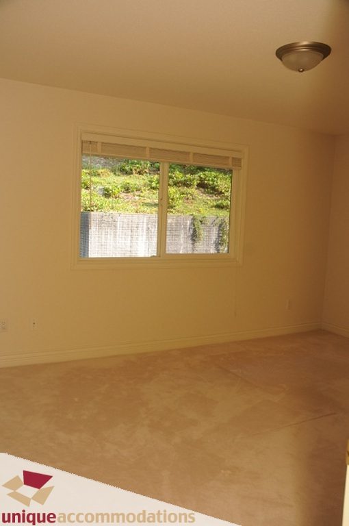 Spacious bedroom with large window and carpeted floor. - 4139 Citadel Court, North Vancouver