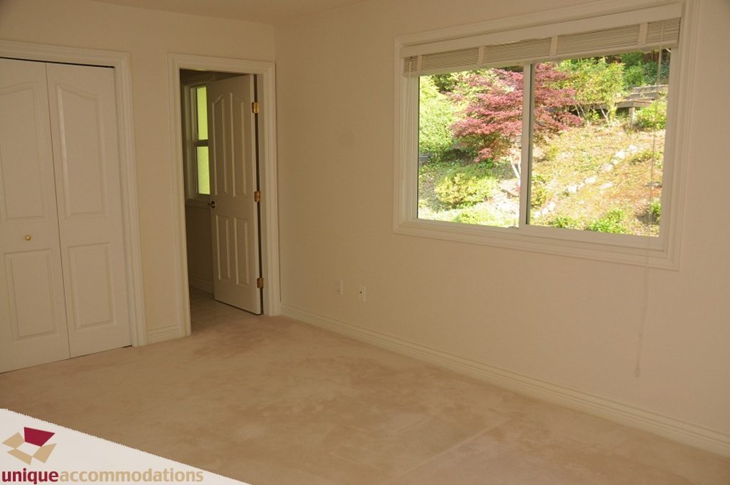 Bright bedroom with carpeted floor and view of greenery outside. - 4139 Citadel Court, North Vancouver