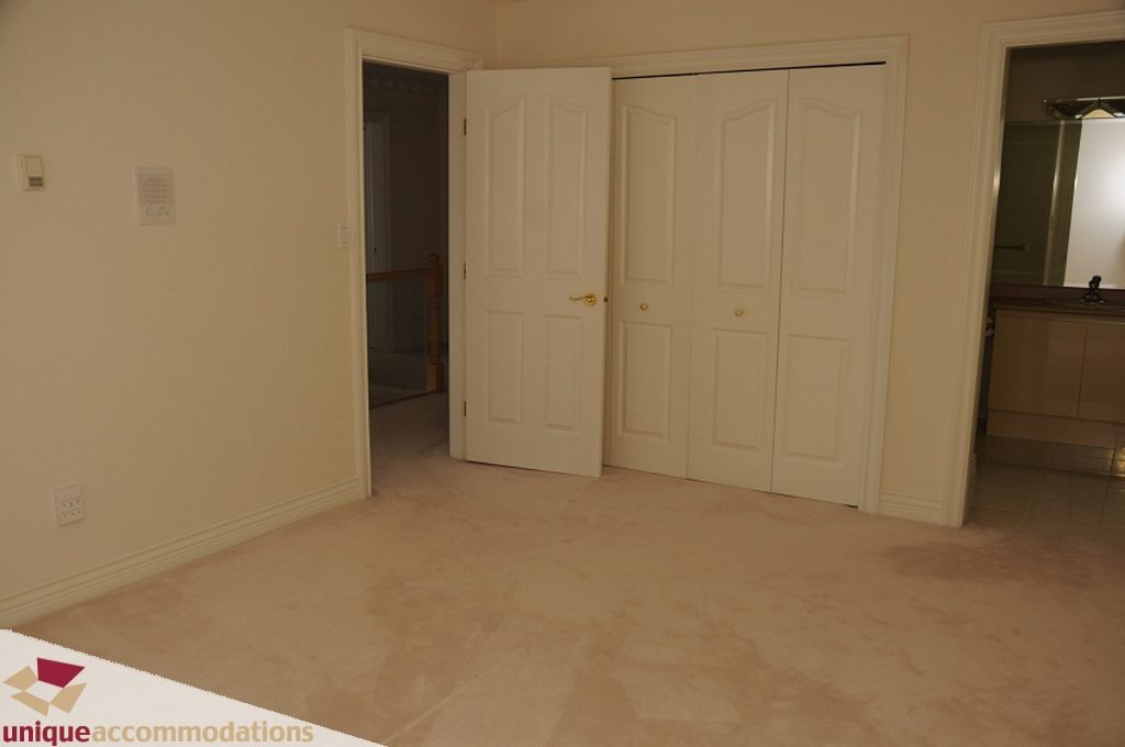 Bright entryway with white doors and tiled floor, leading to a hallway with a staircase. - 4139 Citadel Court, North Vancouver