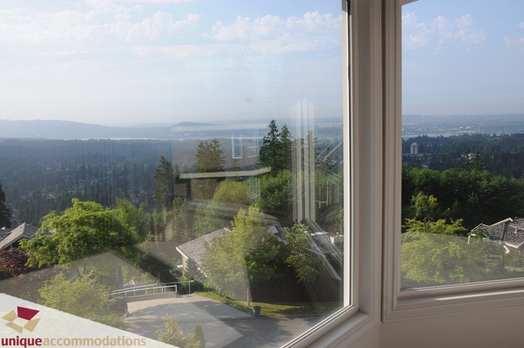 Bright living room with expansive city view and lush greenery. - 4139 Citadel Court, North Vancouver