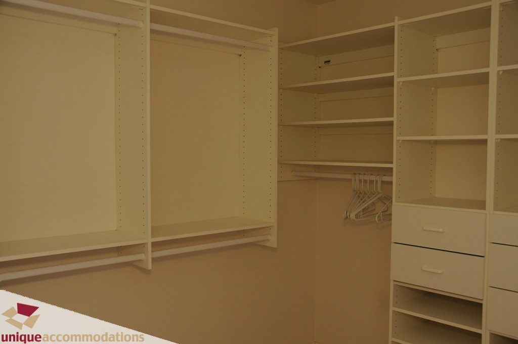 Empty walk-in closet with white shelving and hangers. - 4139 Citadel Court, North Vancouver