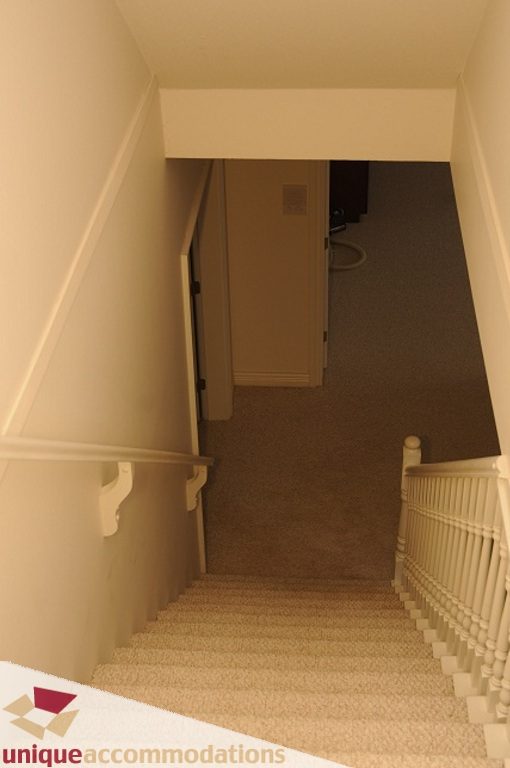Staircase leading to upper level with carpeted steps and white railing. - 4139 Citadel Court, North Vancouver