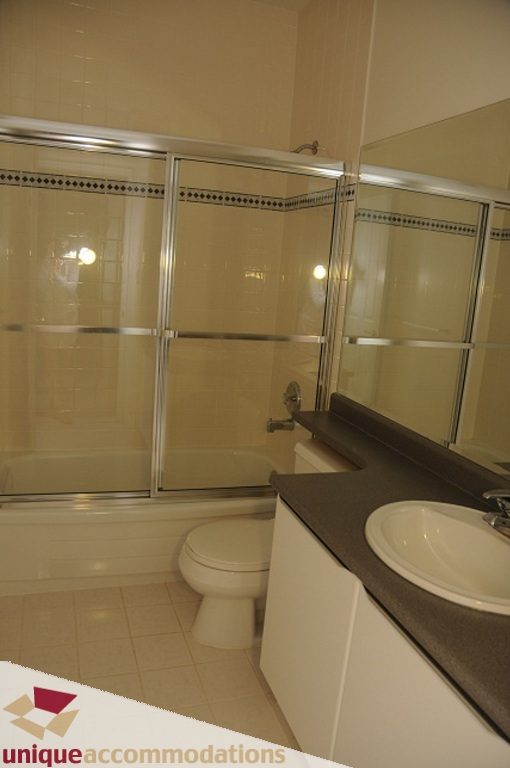 Bathroom with modern sink, countertop, and sliding glass shower. - 4139 Citadel Court, North Vancouver