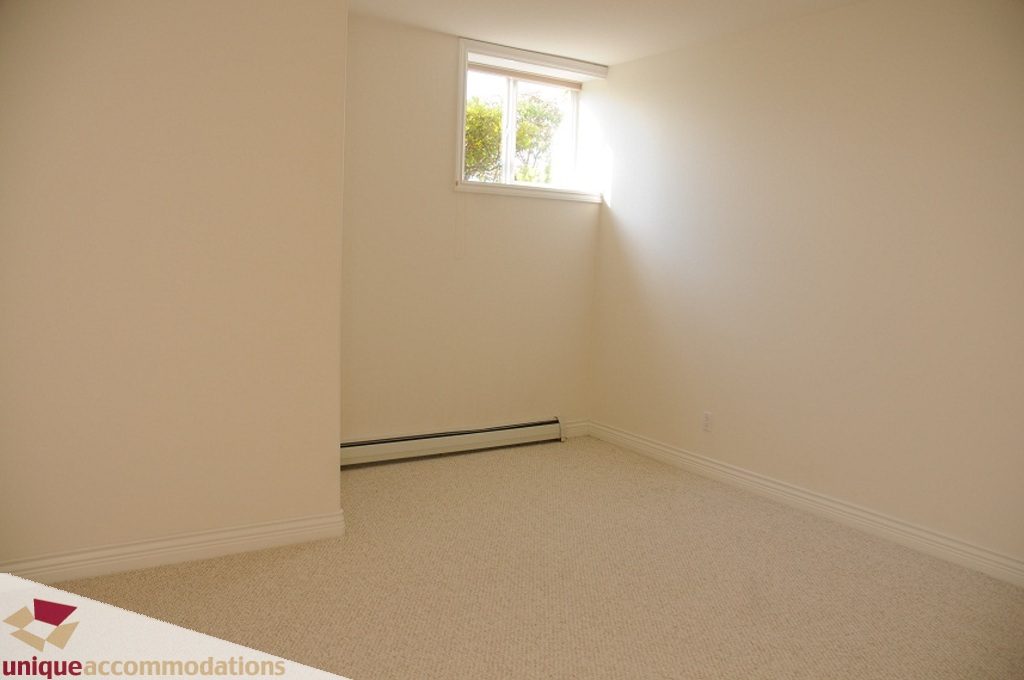 Bright bedroom with carpeted floor and small window. - 4139 Citadel Court, North Vancouver
