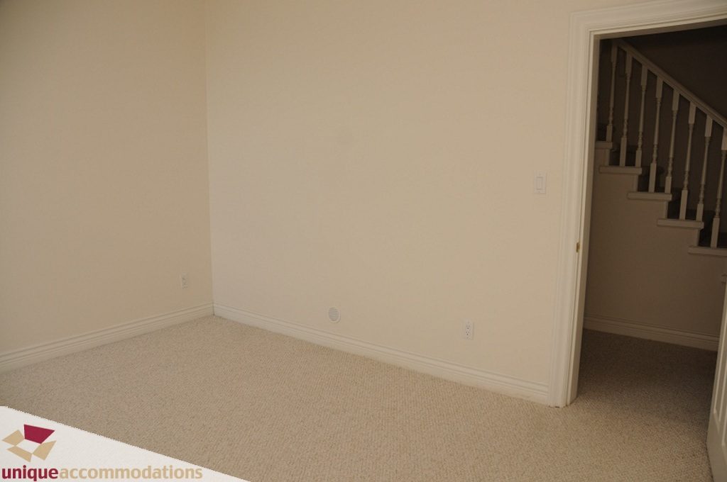 Empty living room with beige carpet and white walls. - 4139 Citadel Court, North Vancouver