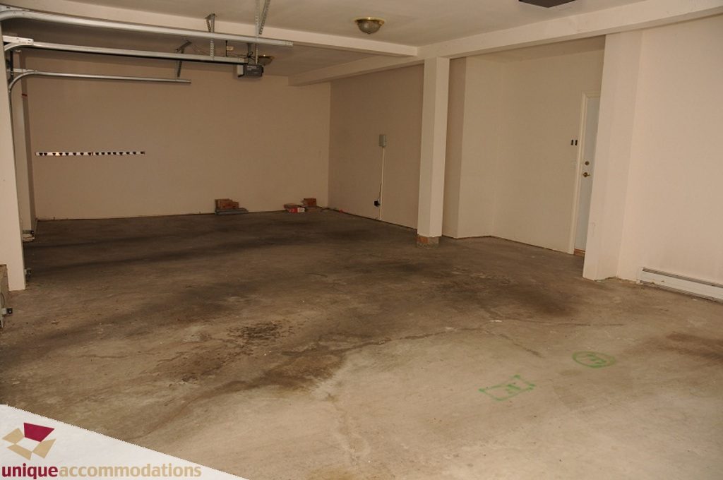Empty garage with concrete floor and visible garage door mechanism. - 4139 Citadel Court, North Vancouver