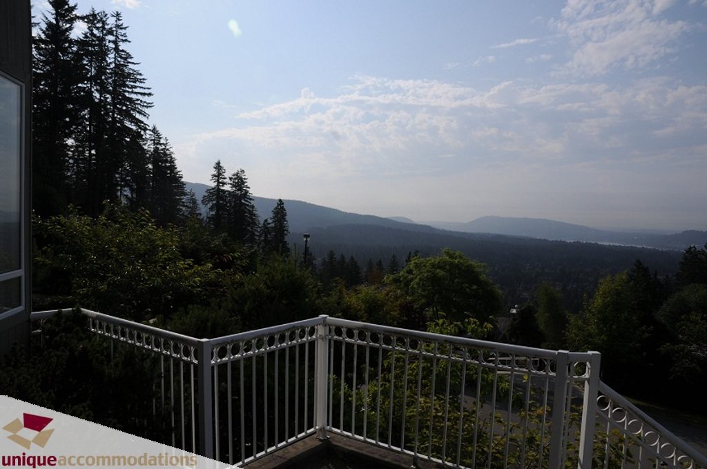 Balcony with white railing, overlooking forest and mountains. - 4139 Citadel Court, North Vancouver