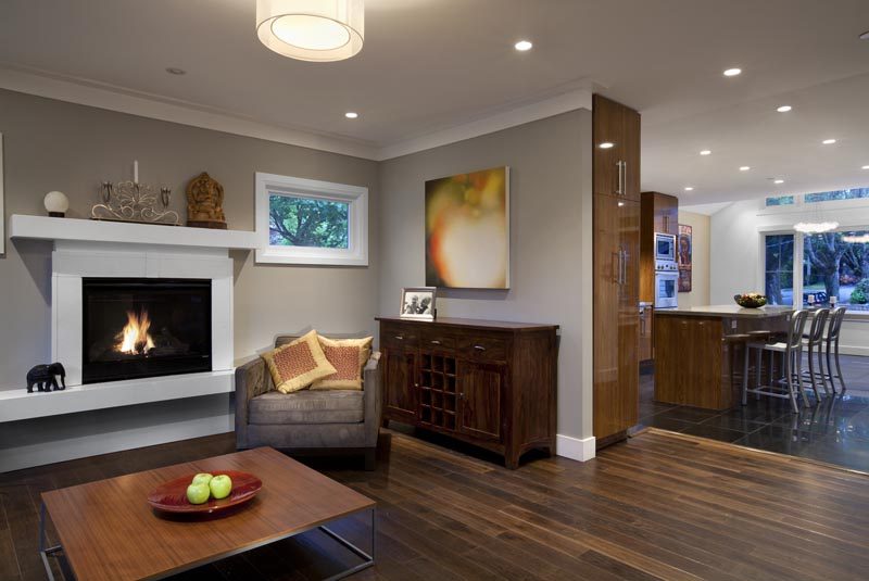 Living room with hardwood floors, modern fireplace, and kitchen counter in background. - 4104 West 12th Avenue, Vancouver West Side