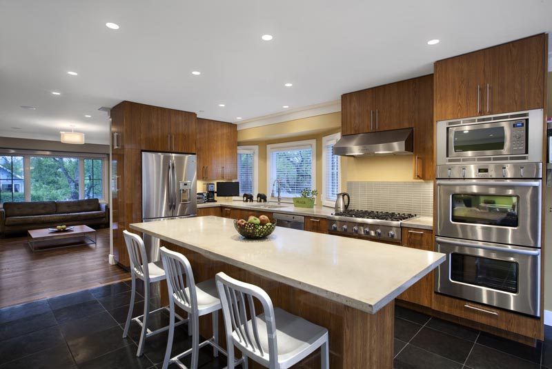 Bright kitchen with modern stainless steel appliances, granite countertops, and hardwood floors. - 4104 West 12th Avenue, Vancouver West Side
