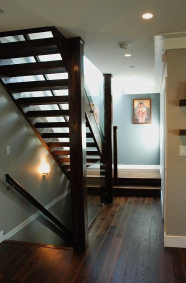 Staircase with dark wood treads and handrail, leading to a light blue wall with framed artwork. - 4104 West 12th Avenue, Vancouver West Side