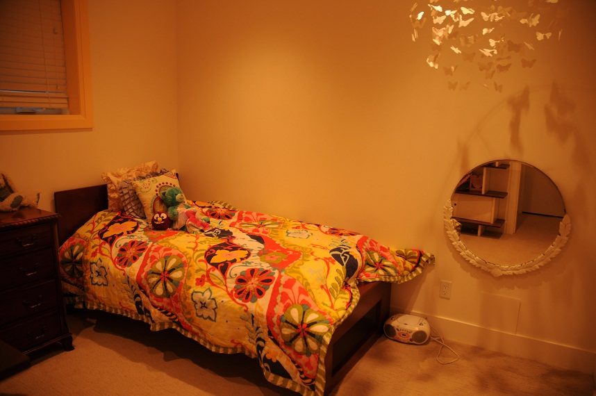 Bright bedroom with colorful quilt and butterfly wall decor. - 4104 West 12th Avenue, Vancouver West Side