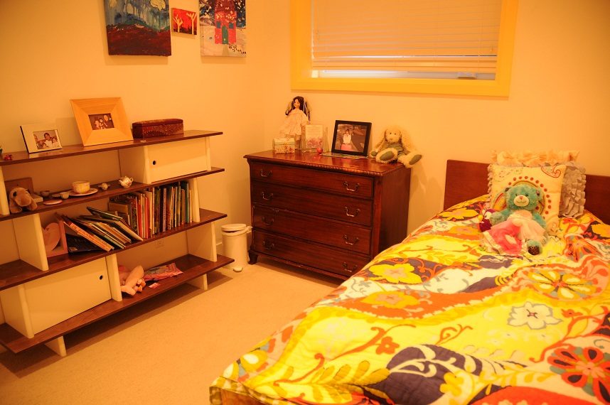 Bright bedroom with colorful bedding, wooden furniture, and child-friendly decor. - 4104 West 12th Avenue, Vancouver West Side