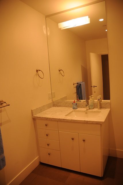 Bathroom with marble countertop and white cabinets. - 4104 West 12th Avenue, Vancouver West Side