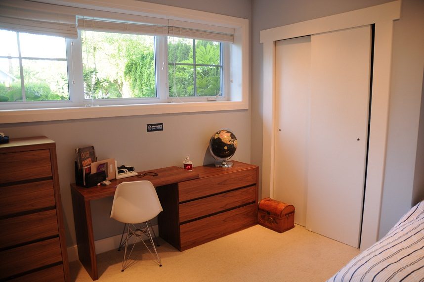 Bright bedroom with wooden desk, globe, and window view. - 4104 West 12th Avenue, Vancouver West Side