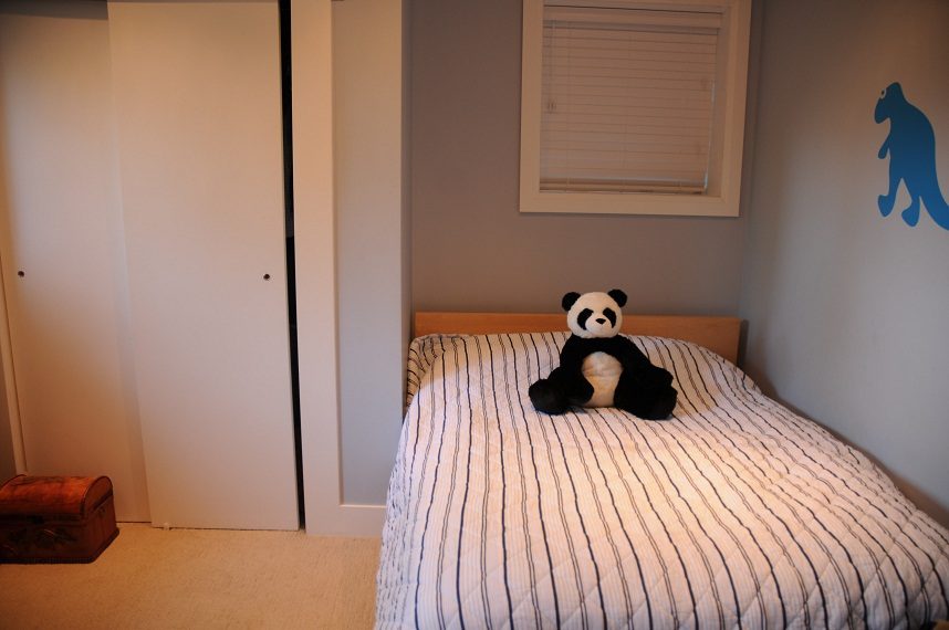 Furnished bedroom with striped bedding and a panda plush on the bed. - 4104 West 12th Avenue, Vancouver West Side