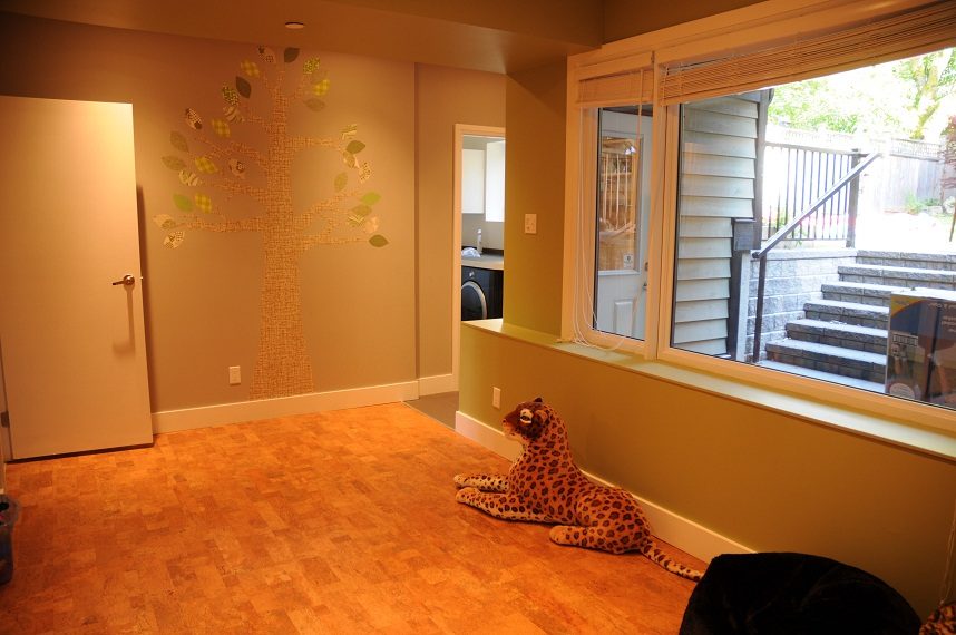 Living room with cork flooring and a tree mural on the wall. - 4104 West 12th Avenue, Vancouver West Side
