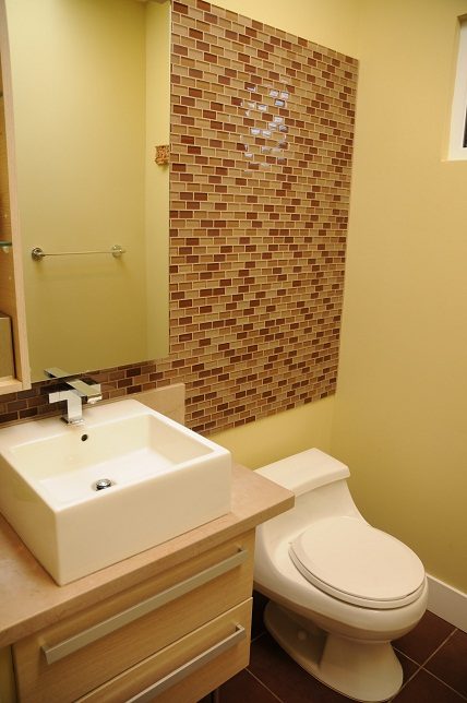 Bathroom with modern sink, brick accent wall, and toilet. - 4104 West 12th Avenue, Vancouver West Side