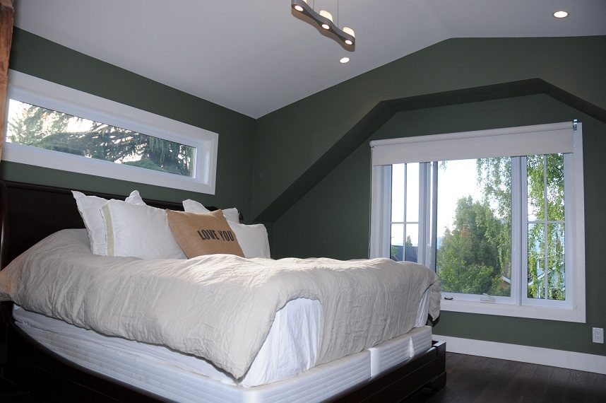 Furnished bedroom with green walls, large windows, and a cozy bed setup. - 4104 West 12th Avenue, Vancouver West Side