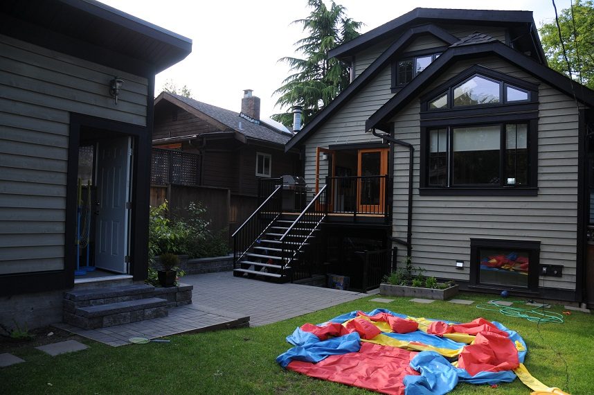 Bright living room with a cozy fireplace and outdoor patio access. - 4104 West 12th Avenue, Vancouver West Side