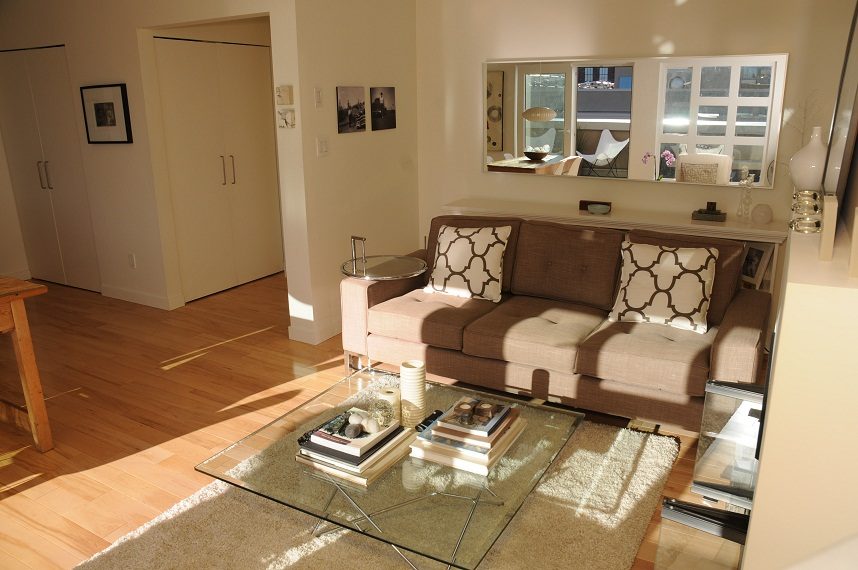 Bright living room with hardwood floors, a modern sofa, and a glass coffee table. - 411- 2161 West 12th Avenue, Vancouver West Side