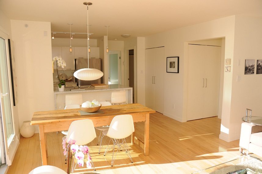 Bright dining area with wooden table, white chairs, and modern pendant lights. - 411- 2161 West 12th Avenue, Vancouver West Side