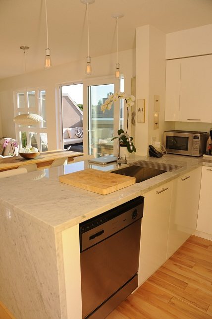 Bright kitchen with marble countertops, hardwood floors, and a view of the living area. - 411- 2161 West 12th Avenue, Vancouver West Side
