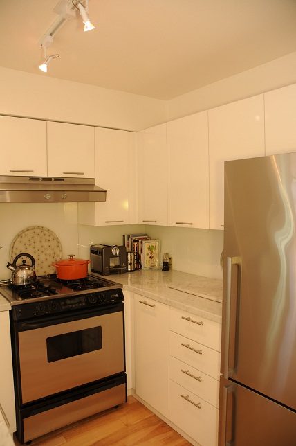 Bright kitchen with white cabinets, stainless steel appliances, and hardwood floors. - 411- 2161 West 12th Avenue, Vancouver West Side