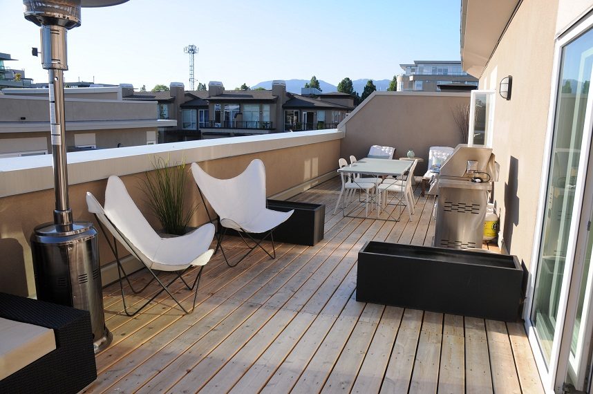Furnished rooftop patio with wooden deck, modern chairs, and city view. - 411- 2161 West 12th Avenue, Vancouver West Side