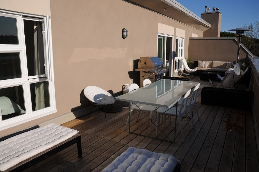 Furnished patio with wooden deck, glass table, and outdoor seating. - 411- 2161 West 12th Avenue, Vancouver West Side