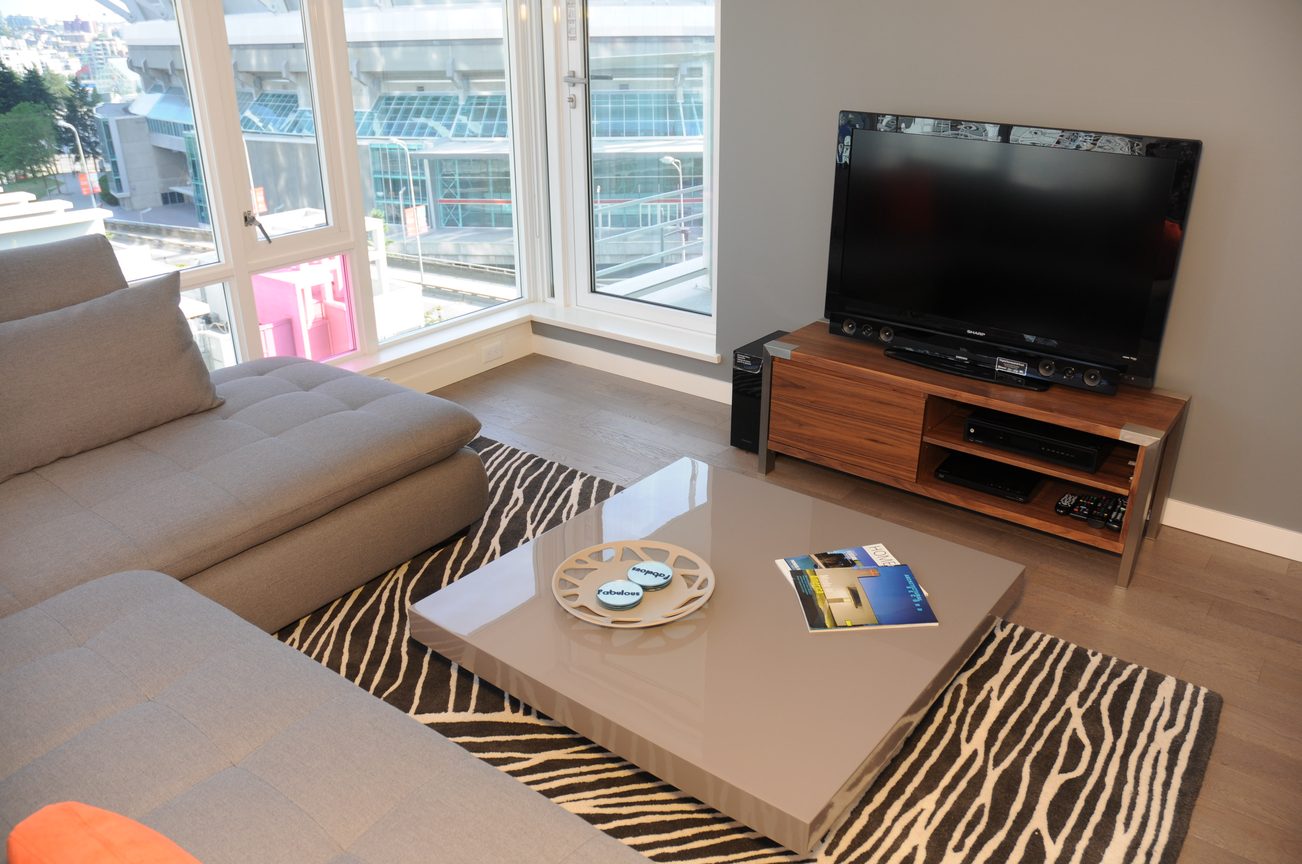 Bright living room with large windows, city view, modern furniture, and zebra-patterned rug. - 801 - 161 West Georgia, Vancouver Downtown