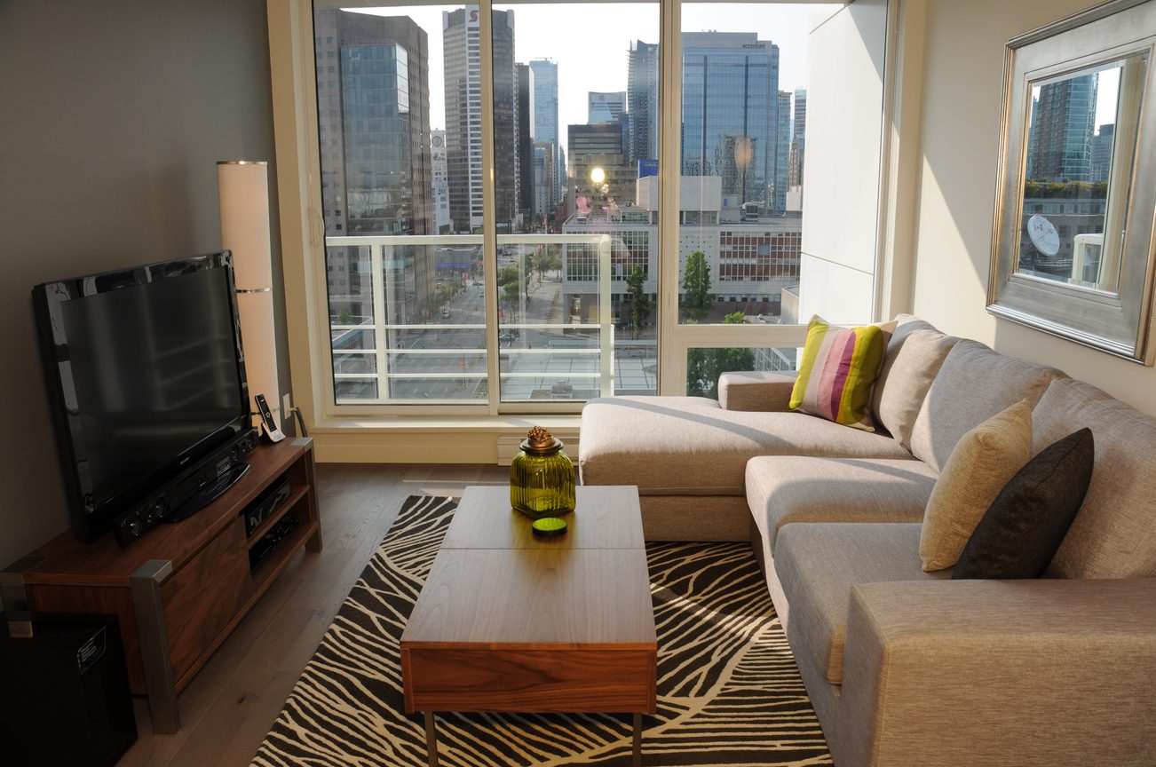 Furnished living room with city view, hardwood floors, and zebra-patterned rug. - 2009 - 161 West Georgia, Vancouver Downtown