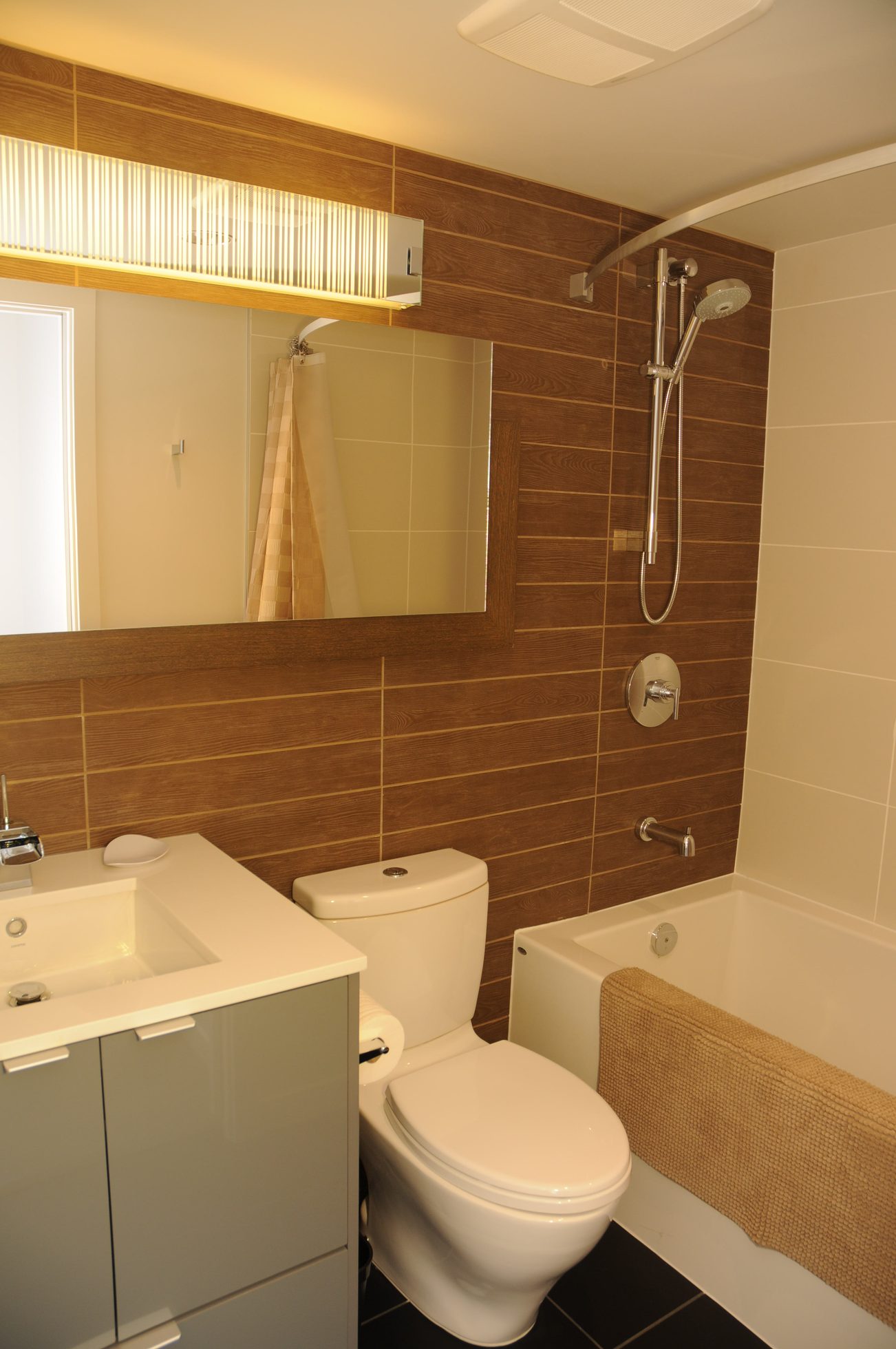 Furnished bathroom with wooden paneling, modern fixtures, and a bathtub. - 2009 - 161 West Georgia, Vancouver Downtown