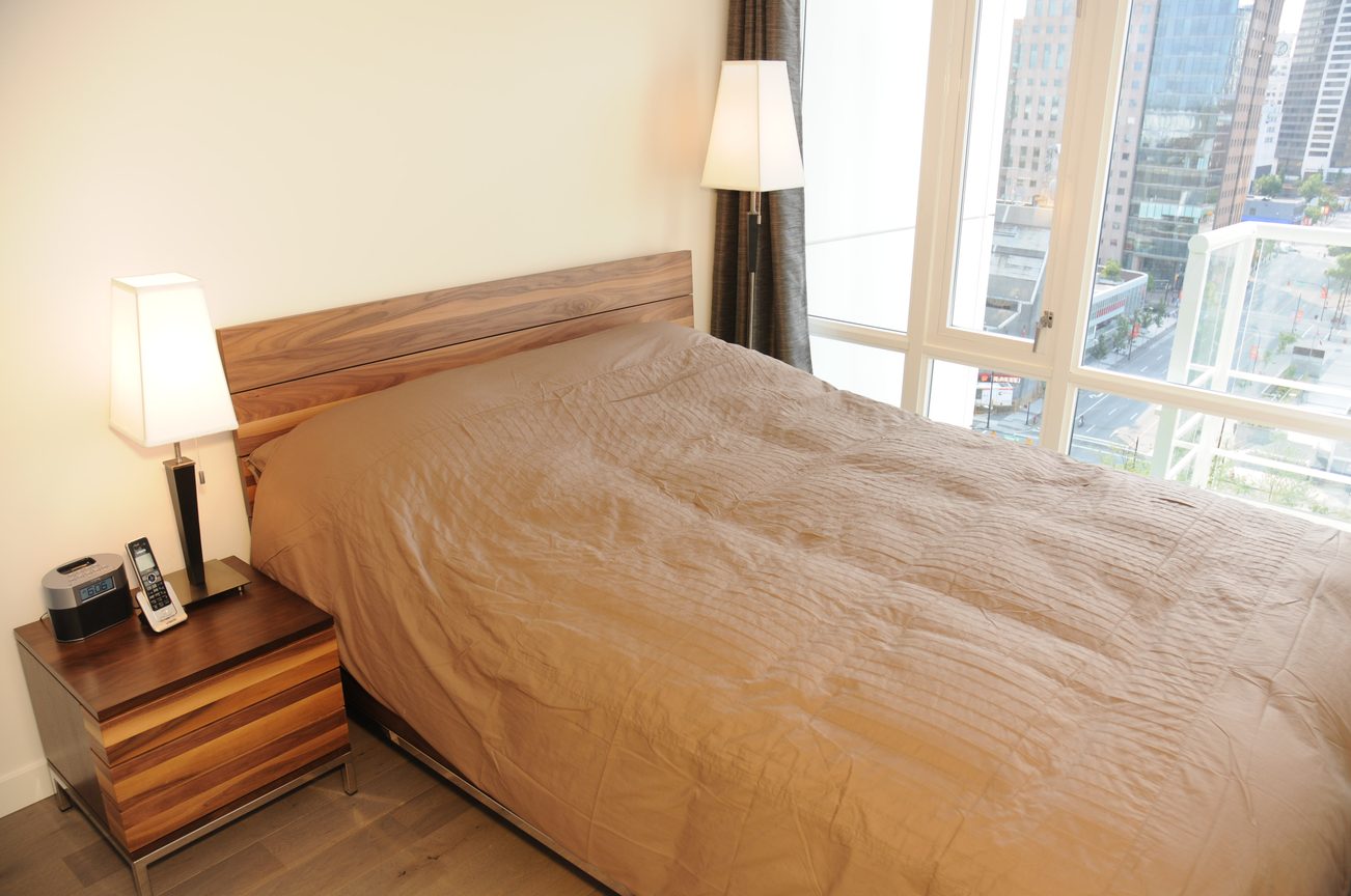 Bright bedroom with wooden furniture, hardwood floors, and a city view. - 2009 - 161 West Georgia, Vancouver Downtown