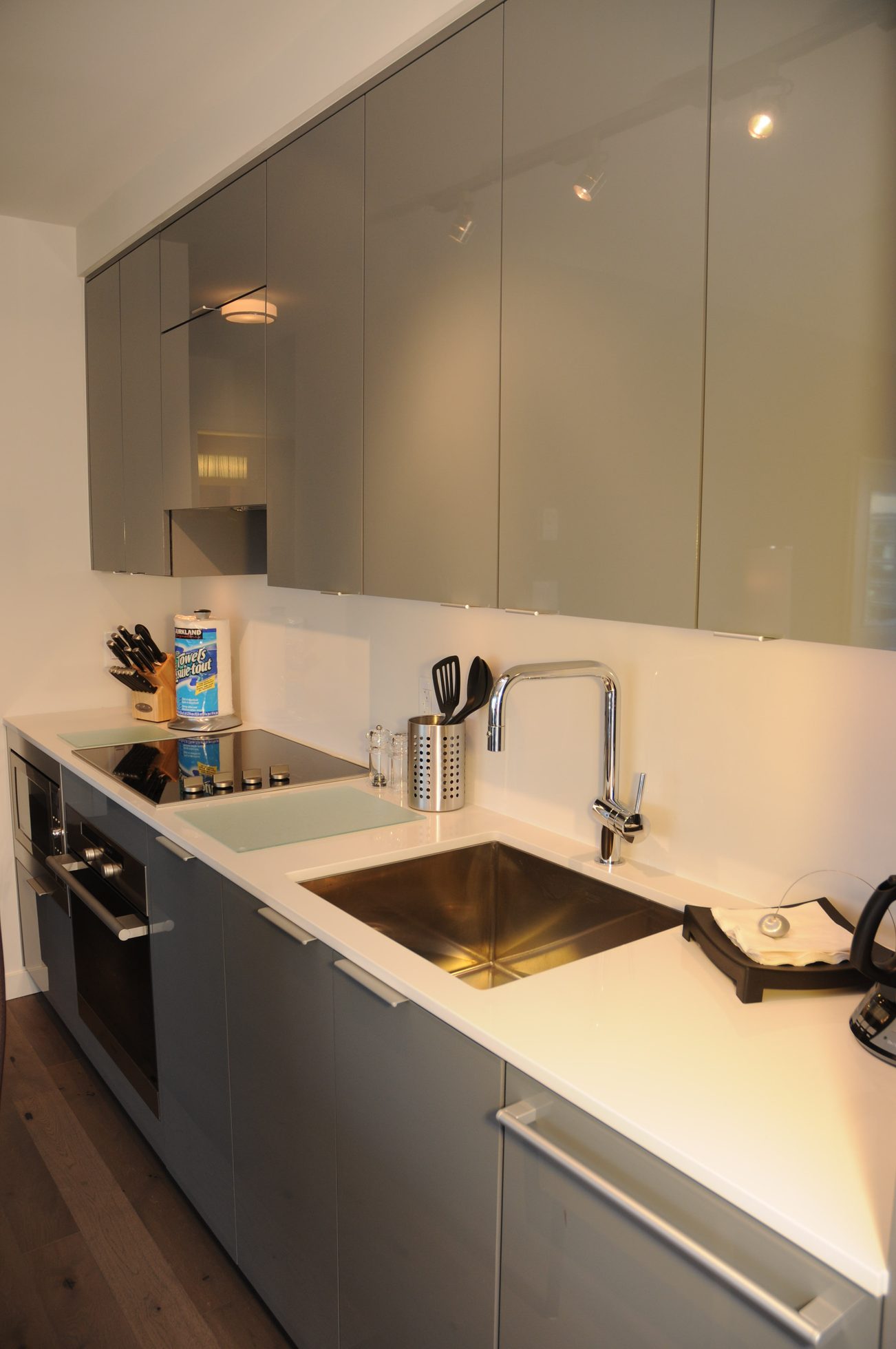 Bright kitchen with white countertops, stainless steel sink, and gray cabinets. - 2201 - 161 West Georgia, Vancouver Downtown