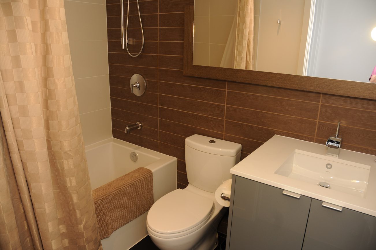 Bright bathroom with wooden accents, modern sink, and bathtub. - 2201 - 161 West Georgia, Vancouver Downtown