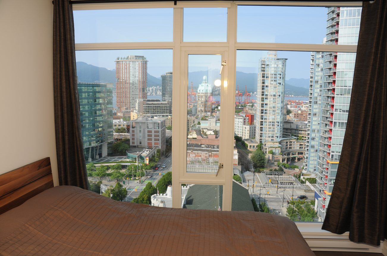 Furnished bedroom with a stunning city view and modern furnishings. - 2201 - 161 West Georgia, Vancouver Downtown