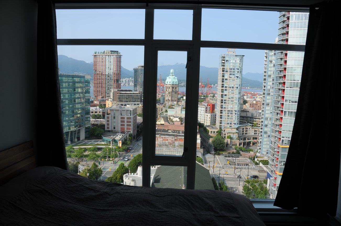 Furnished bedroom with a stunning city view and modern furnishings. - 2201 - 161 West Georgia, Vancouver Downtown