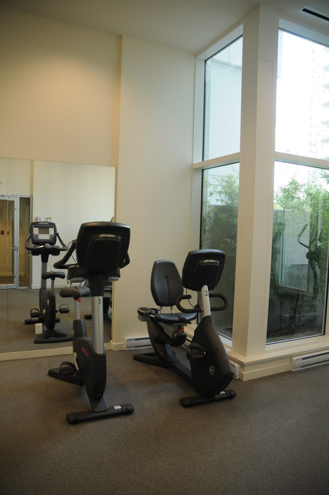 Bright gym with exercise bikes and large windows, city view. - 2201 - 161 West Georgia, Vancouver Downtown