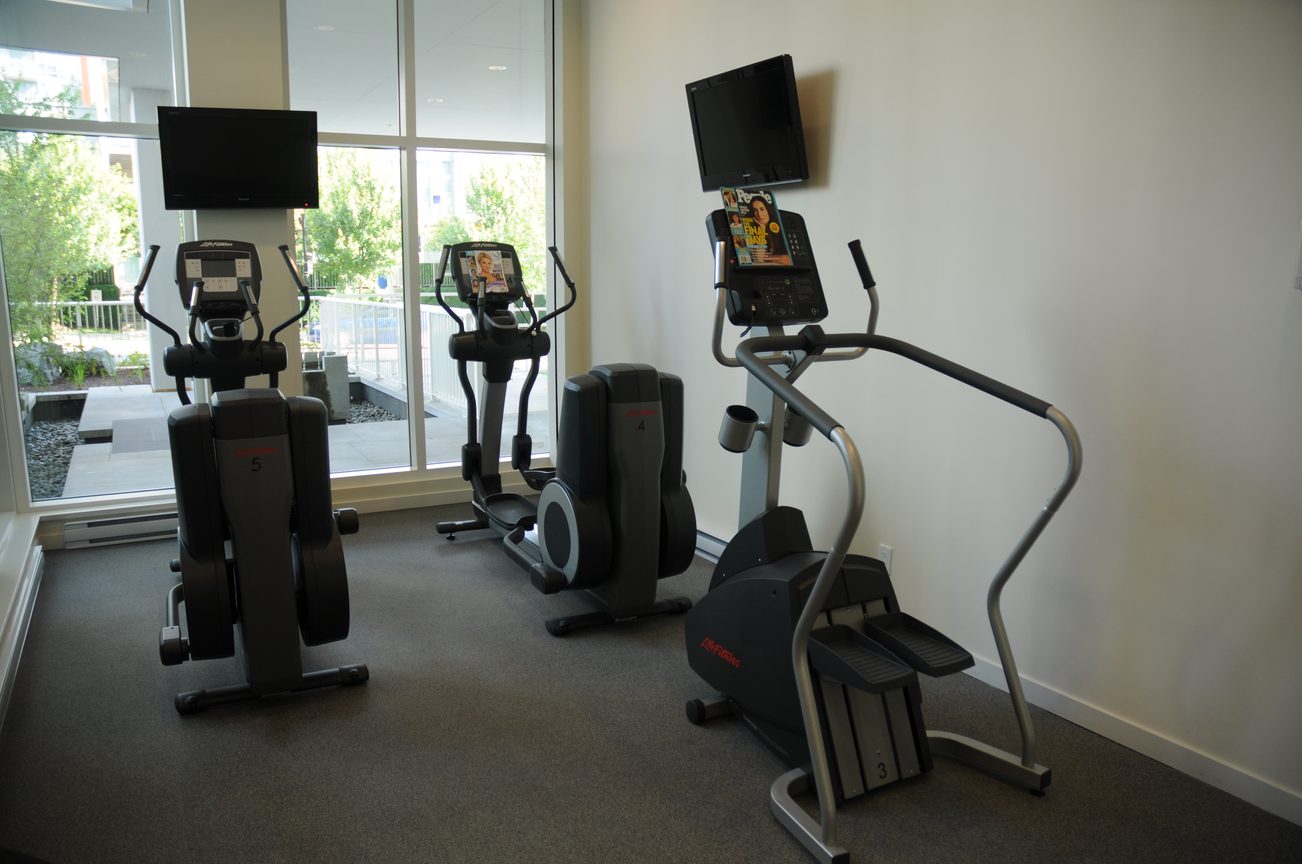 Bright and modern fitness room with elliptical machines and city view. - 2201 - 161 West Georgia, Vancouver Downtown