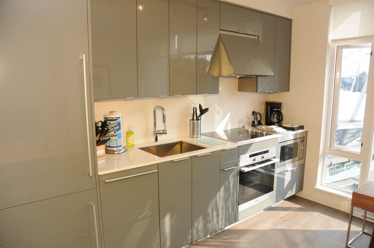 Bright kitchen with modern appliances, hardwood floors, and a city view. - 2206 - 161 West Georgia St, Vancouver Downtown
