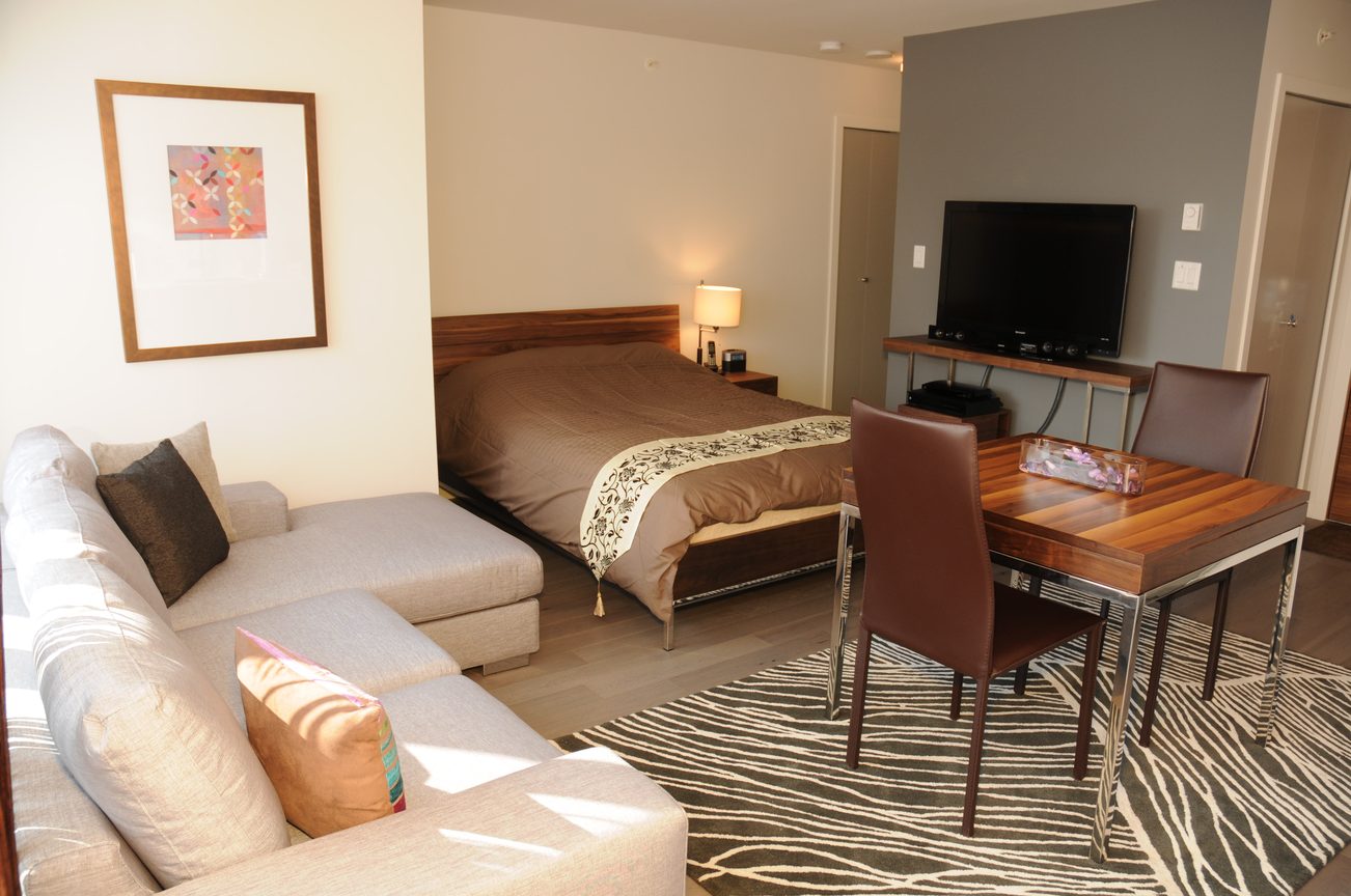 Furnished living room with modern furniture, zebra-patterned rug, and a cozy sofa. - 2206 - 161 West Georgia St, Vancouver Downtown