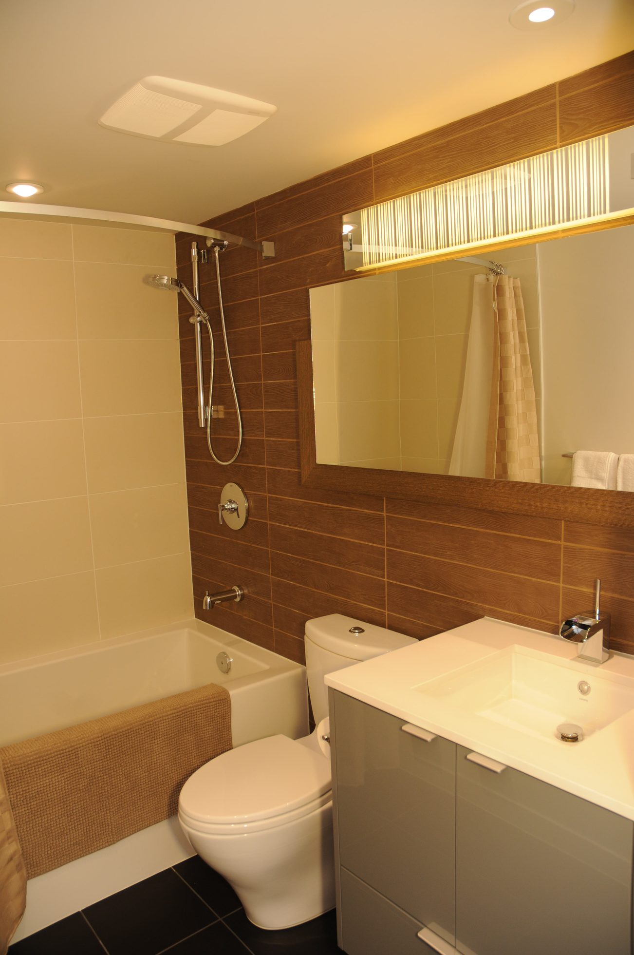 Furnished bathroom with modern fixtures, wood paneling, and a large mirror. - 2206 - 161 West Georgia St, Vancouver Downtown