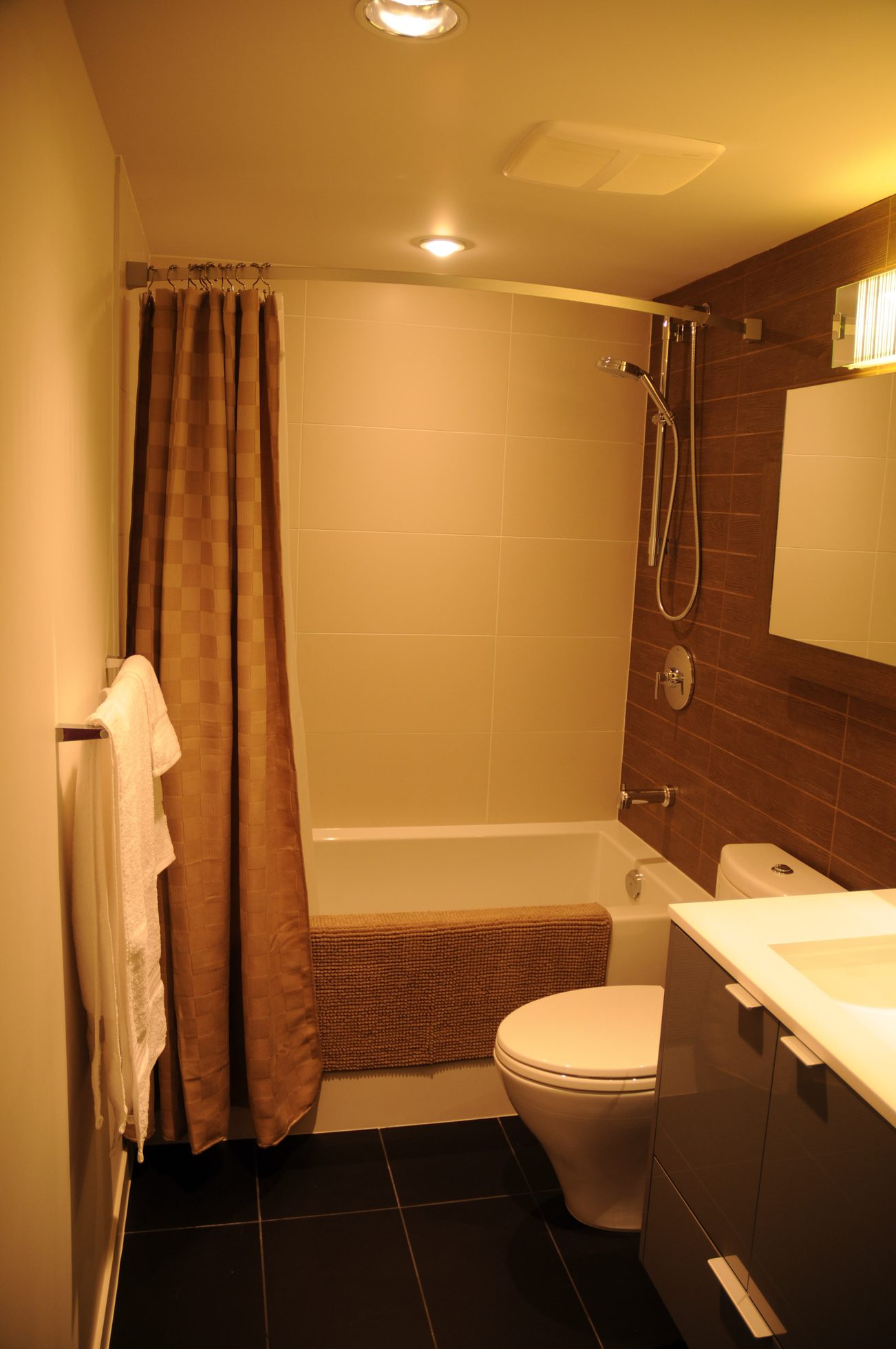 Furnished bathroom with a bathtub, shower, and dark wood accents. - 2206 - 161 West Georgia St, Vancouver Downtown