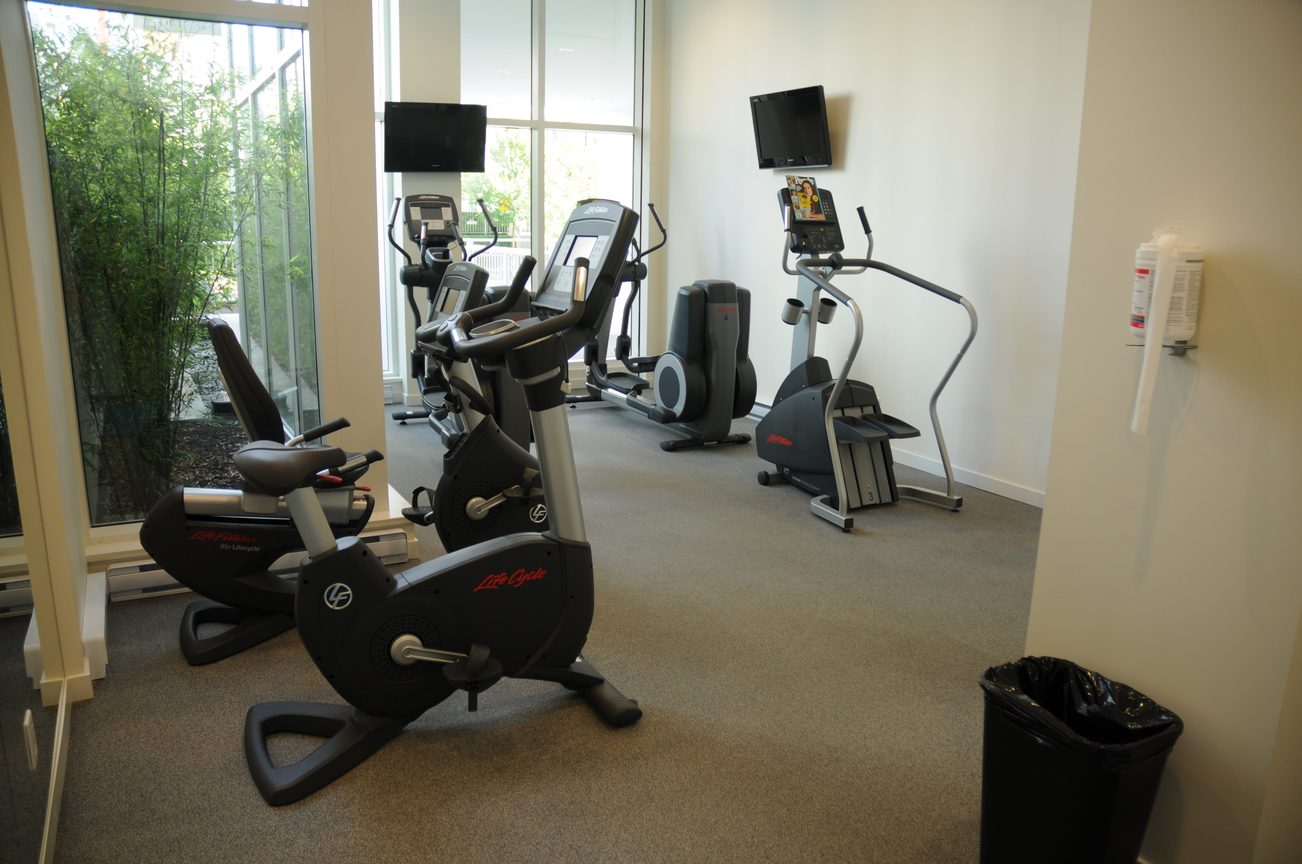 Bright fitness room with cardio machines and large windows. - 2206 - 161 West Georgia St, Vancouver Downtown