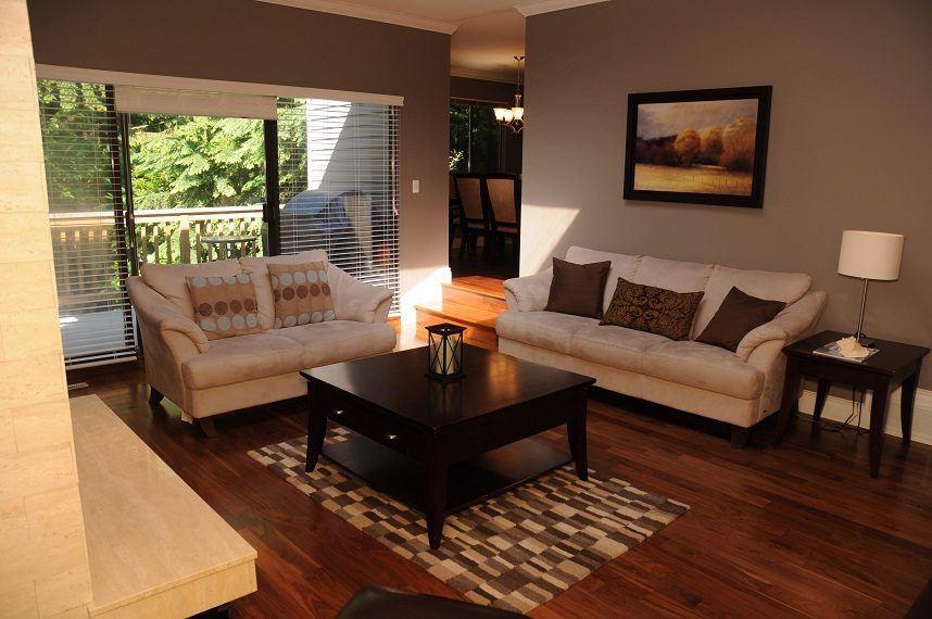 Living room with hardwood floors, cozy beige furniture, and a large window view. - 5591 Huckleberry Place, North Vancouver