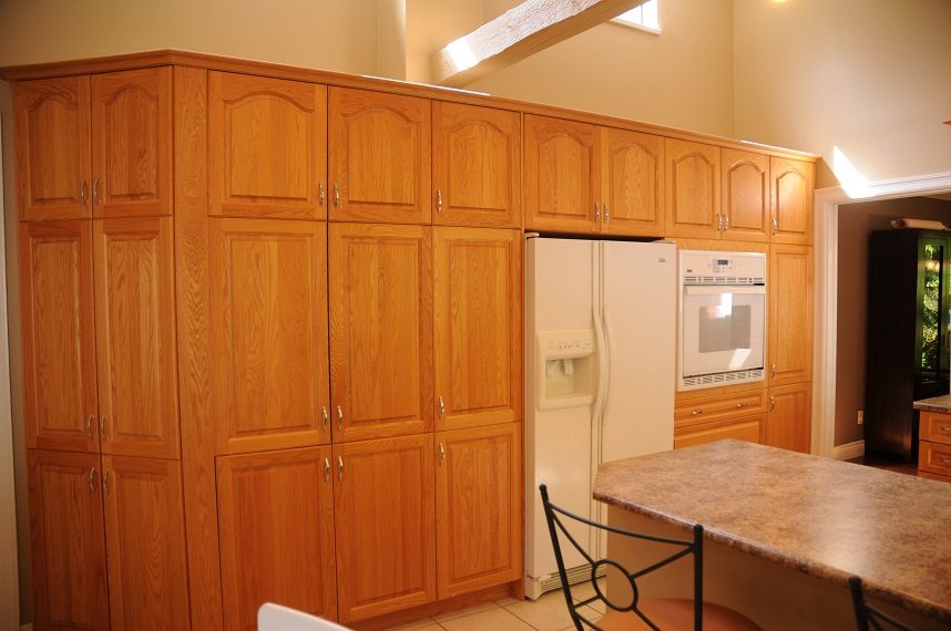 Bright kitchen with wooden cabinets, granite countertops, and a city view. - 5591 Huckleberry Place, North Vancouver