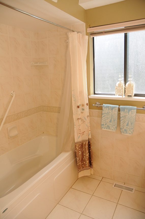 Spacious bathroom with tiled walls, shower, and window. - 5591 Huckleberry Place, North Vancouver